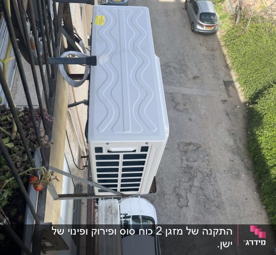 יחידת מיזוג אוויר חיצונית מותקנת על קיר בניין